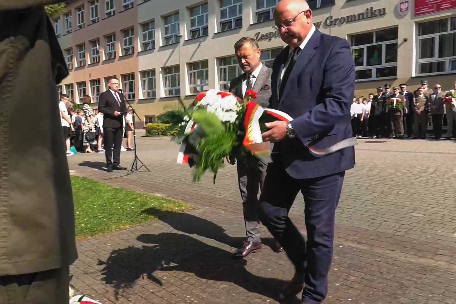 Starosta składa kwiaty przed pomnikiem, obok Mariusz Tyrka