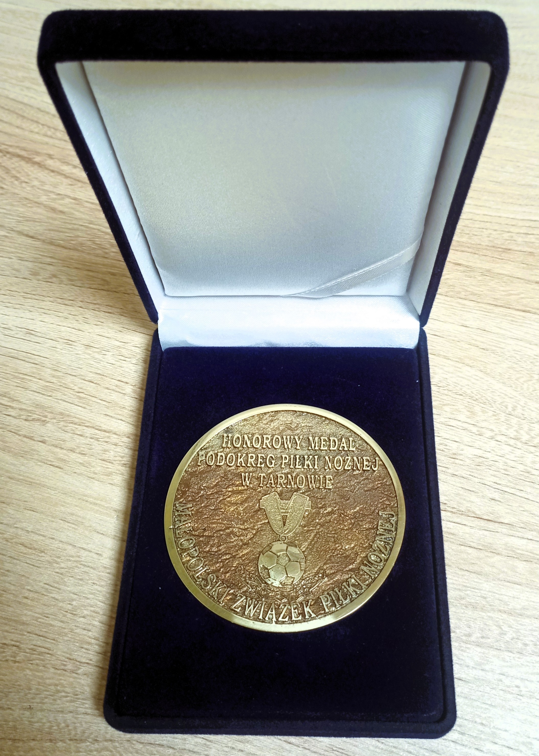 Wyróżnienie w granatowym etui - krążek koloru złotego z nadrukiem