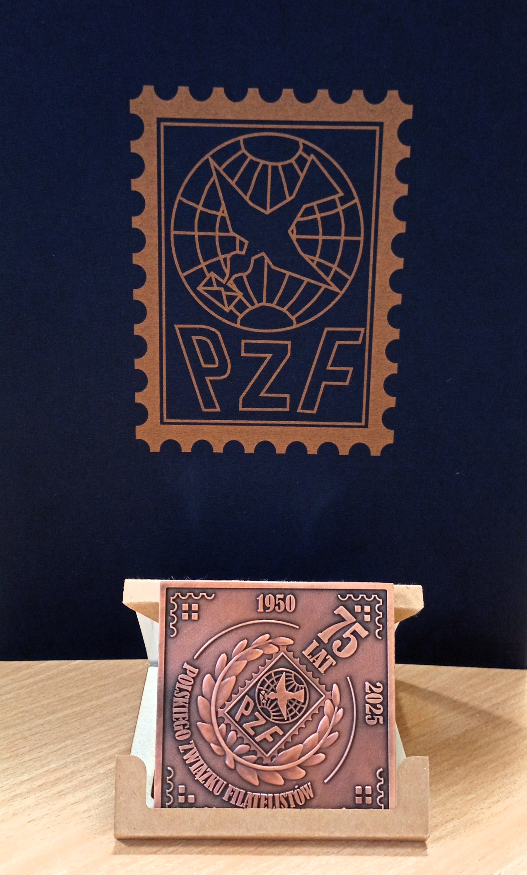 Medal w kształcie kwadratu z wytłoczoną liczbą 75-lecie PZF