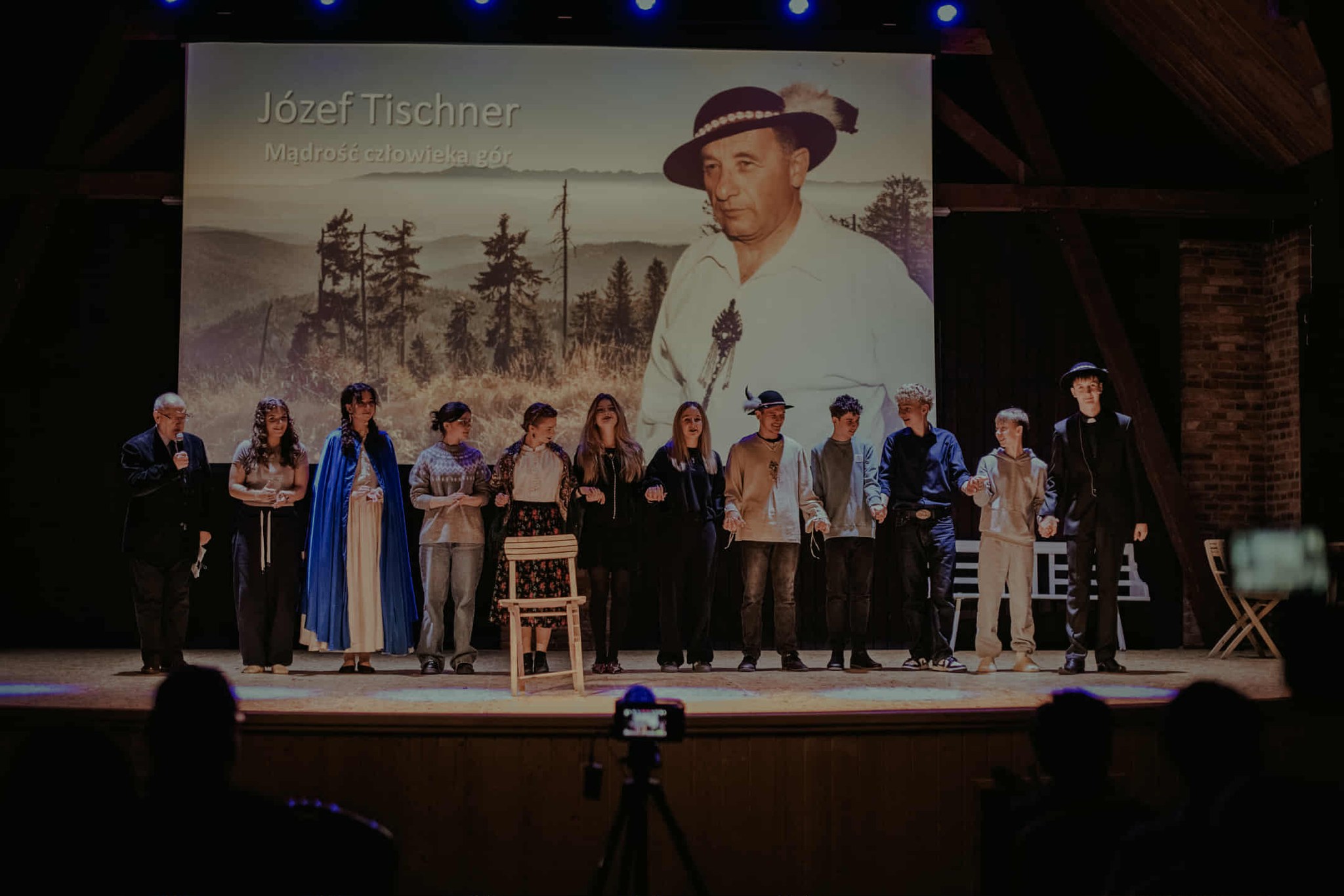 Scena z aktorami, w tle bohater wieczoru