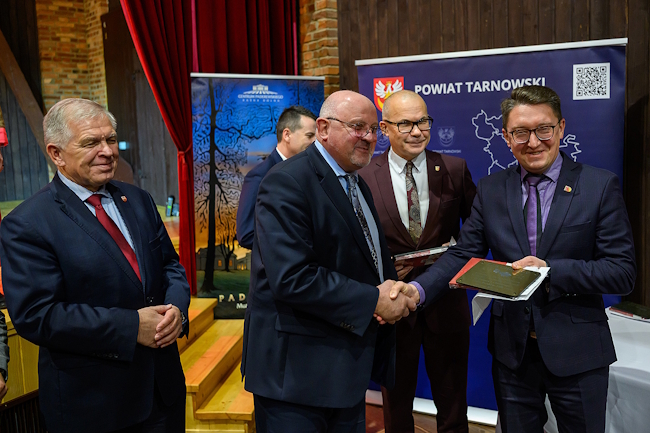 Starosta wraz z zarządem powiatu podczas wręczania pamiątkowych tabliczek przedstawicielom samorządów lokalnych