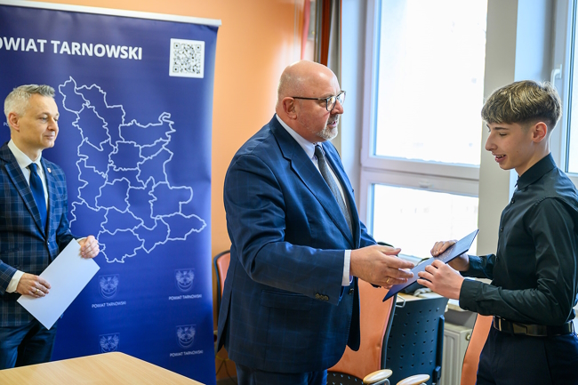 starosta gratuluje sukcesu młodemu mistrzowi wręczając przyznana nagrodę