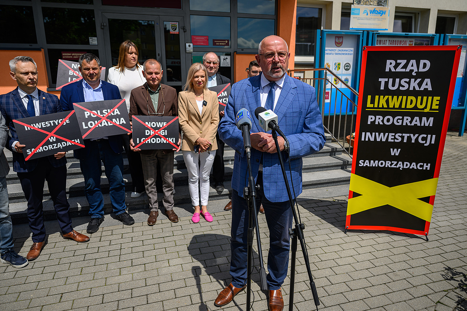 Starosta tarnowski Jacek Hudyma podczas konferencji, w tle samorządowcy z regionu