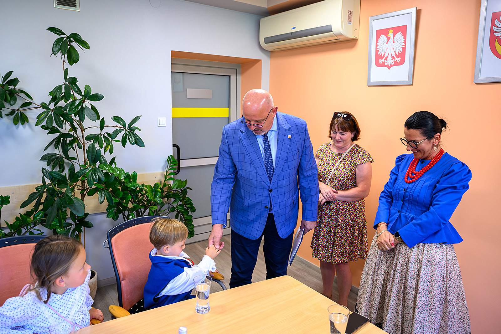 Starosta podaje rękę małemu tancerzowi w stroju ludowym